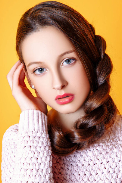 Beautiful Cute fashion girl teenage in a sweater and a skir on yellow background with long hair posing - Foto, Imagem