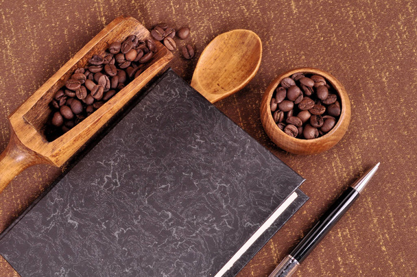 Βιβλίο για συνταγές για καφέ. Φρυγμένους κόκκους καφέ σε ένα ξύλινο μπολ - Φωτογραφία, εικόνα