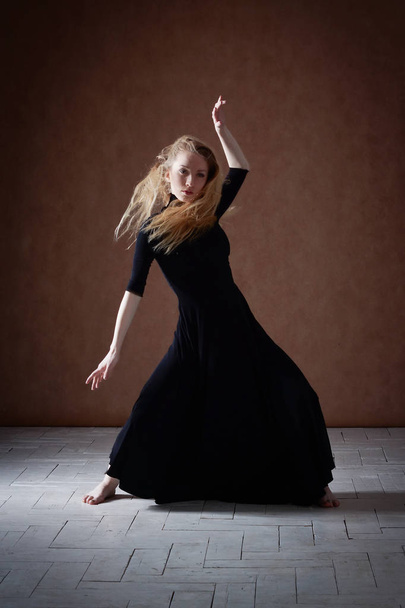 Modern ballet dancer posing on dark background - Foto, imagen