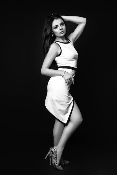 fashion style studio photo of a cute brunette, on black background. Black and white - Фото, изображение