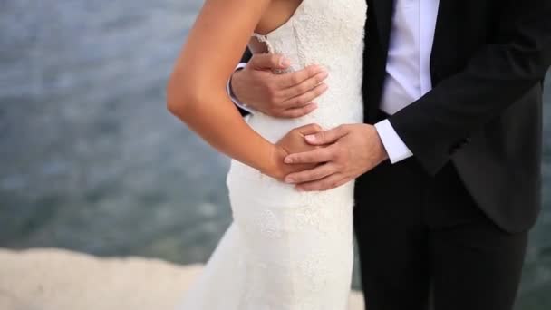 Наречений охоплює наречену на пляжі. Весілля в Чорногорії - Кадри, відео