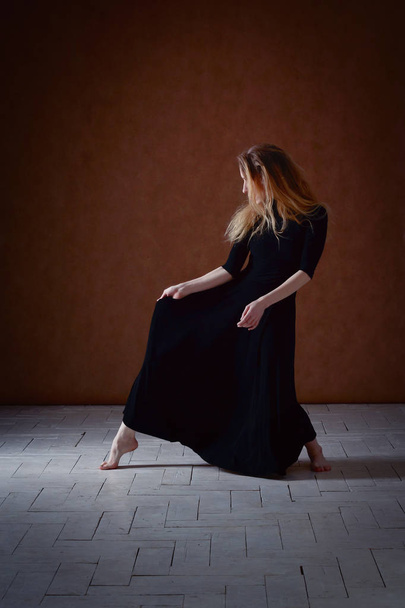 Modern ballet dancer posing on dark background - Foto, Bild