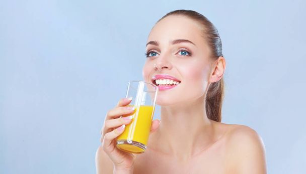 Веселая улыбающаяся девушка с полотенцем, держа стакан апельсинового сока
 - Фото, изображение