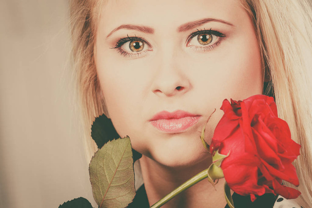 Zbliżenie kobietę czerwona róża w pobliżu twarzy. - Zdjęcie, obraz