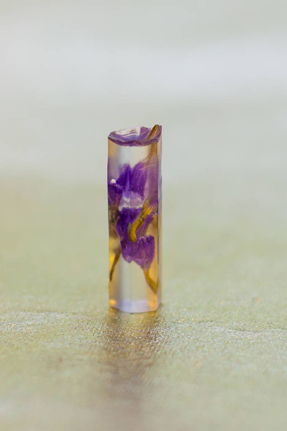 crystal made of epoxy resin and flower close-up - Фото, изображение