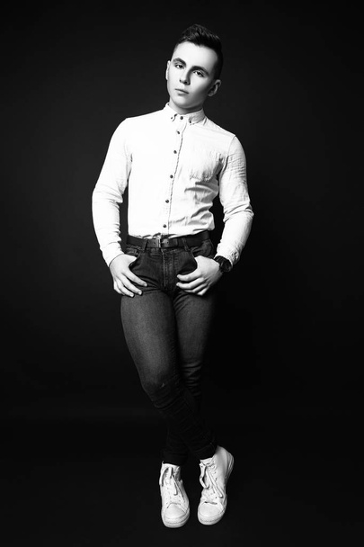 Fashion photo of young model man on black background. Boy posing. Sports guy. Studio photo. Black and white - Valokuva, kuva
