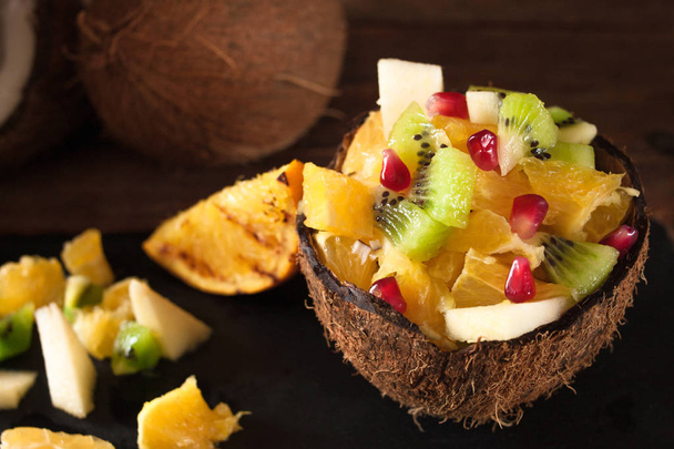 Delicious bright tropical dessert in coconut shell - Foto, afbeelding