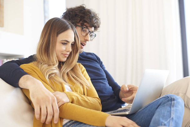couple on couch and using laptop - Photo, image