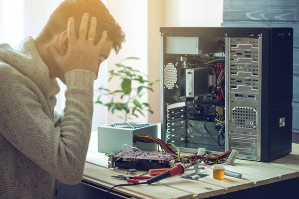 Man repairman broke the computer that was repaired in the service is on a workplace in the office - Valokuva, kuva