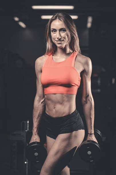 Caucasian pretty fitness girl on diet training pumping up muscle - Photo, Image