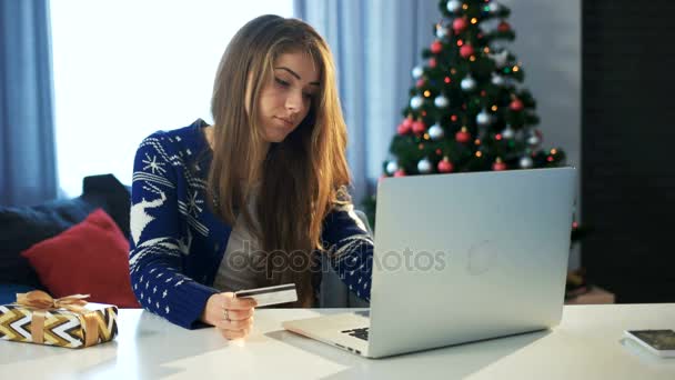 Young girl doing on-line Christmas shopping with her laptop and her credit card - Footage, Video
