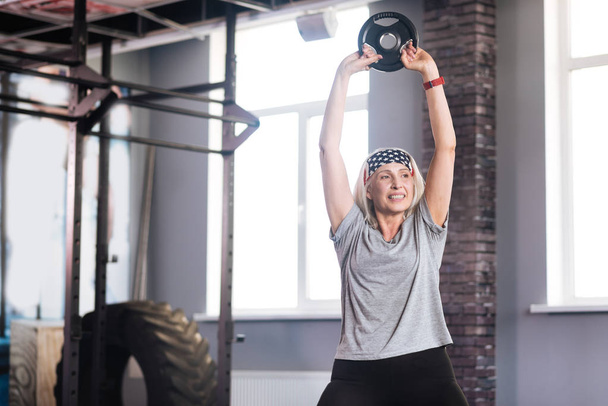 Delighted active woman lifting weights - Valokuva, kuva