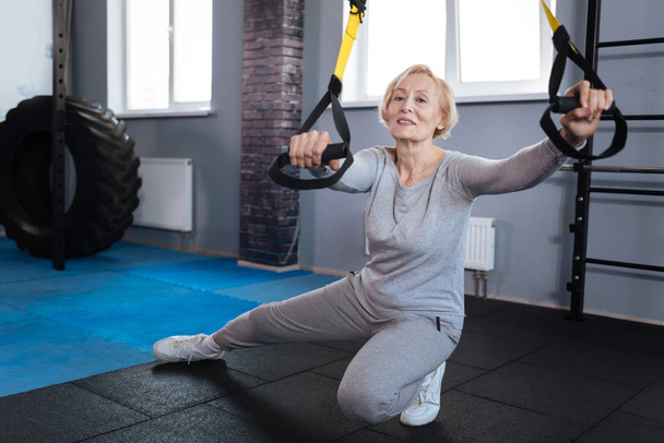 Positive elderly woman concentrating on the workout - Foto, imagen
