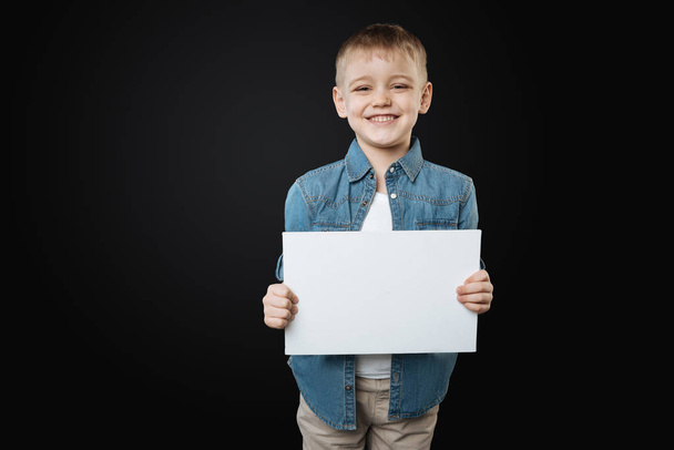 Happy boy holding white paper sheet - Foto, Imagem