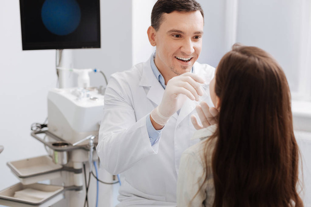 Smiling otolaryngologist checking throat of his patient - Fotografie, Obrázek
