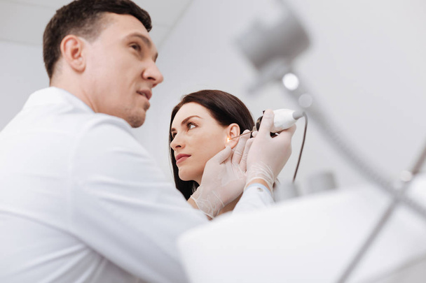 Low angle picture of professional doctor checking female ear - Photo, Image