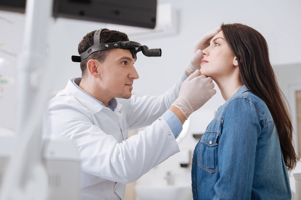 Portrait of otolaryngologist while working with patient - Foto, Bild