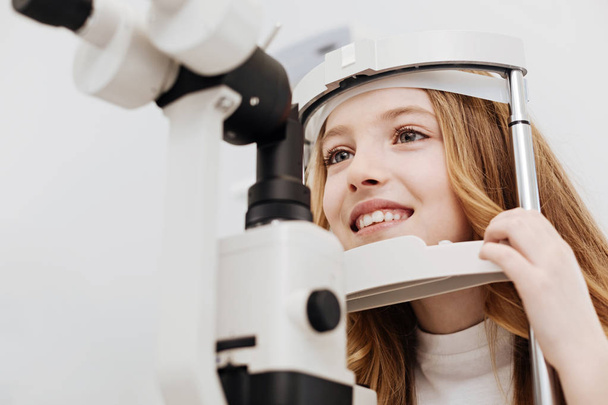Cheerful pretty child getting her eyesight tested - Photo, image