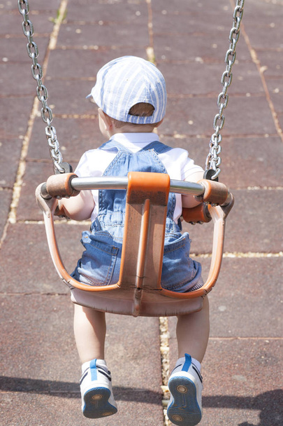 Rapaz de 2 anos a jogar num swing adaptado
 - Foto, Imagem