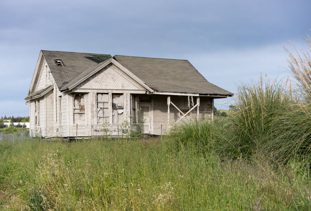 Abandonada casa de família única com tapume de madeira como fixador de propriedade superior
 - Foto, Imagem