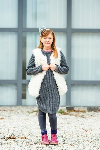 Outdoor portrait of cute 8-9 year old girl wearing grey pullover and white faux fur gilet - Fotografie, Obrázek