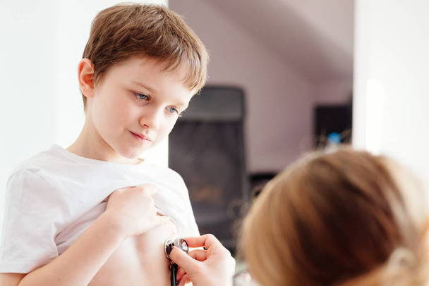Small 7 year old boy is examined by a pediatrician - Fotografie, Obrázek
