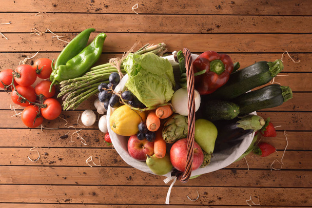 Fruit en groenten op houten tafelblad bekijken - Foto, afbeelding