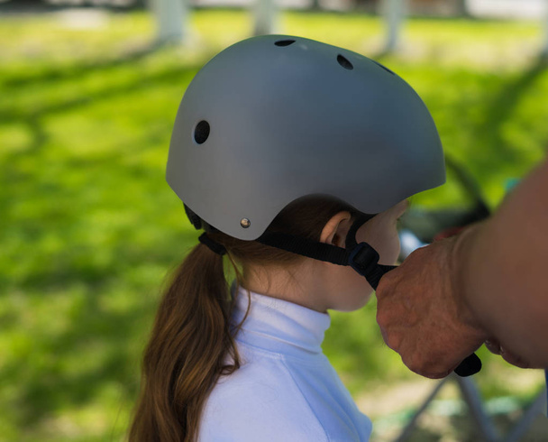 Father putting on safety helmet to his daughter - 写真・画像