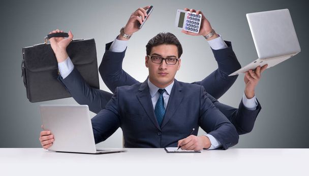 Young businessman in multitasking concept - Fotoğraf, Görsel