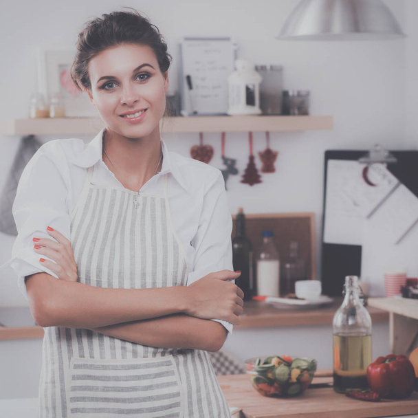 Smiling young woman standing in the kitchen - Foto, Imagem