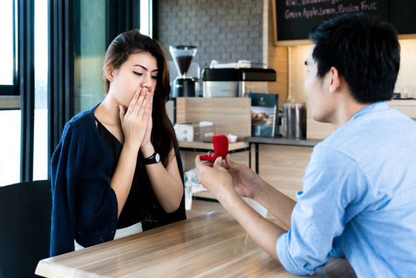 asiatico uomo mostrando un fidanzamento anello diamante per la sua stupito ragazza
 - Foto, immagini