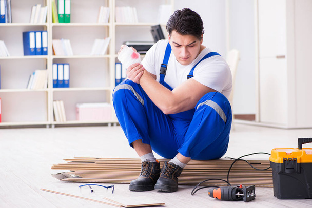 Mladý pracovník pracující na podlahové laminátové dlaždice - Fotografie, Obrázek