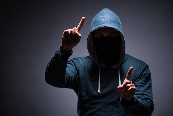 Man wearing hood in dark room - Photo, Image