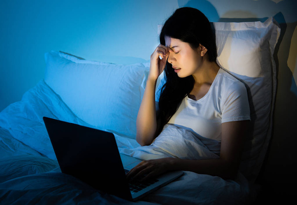 Unhappy woman with computer in the bed - Фото, зображення