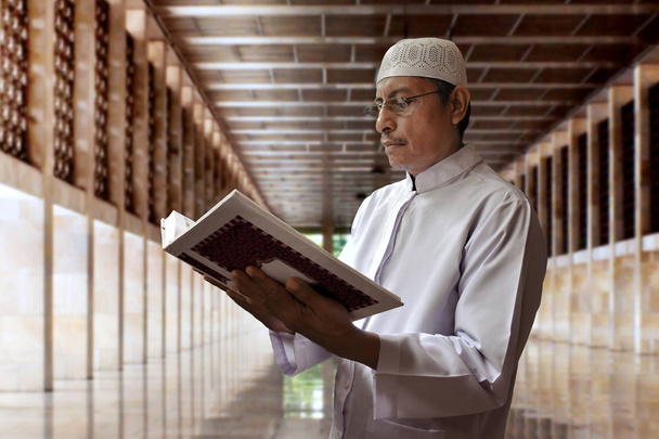 Old muslim man reading koran in mosque - Φωτογραφία, εικόνα