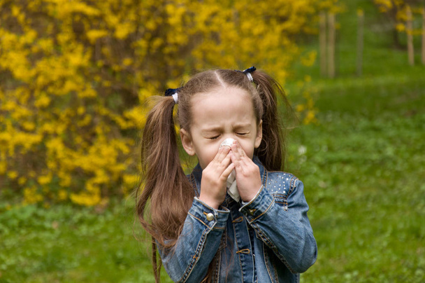 La ragazza ha il naso che cola. allergia al polline dei fiori. La ragazza è una
 - Foto, immagini