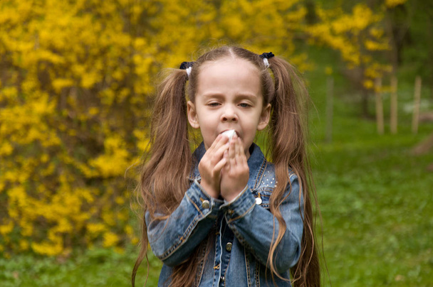 The girl has a runny nose. flowers pollen allergy. The girl is a - Photo, Image