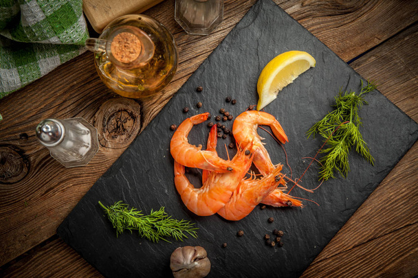 Shrimps for dinner on stone plate. - Foto, afbeelding
