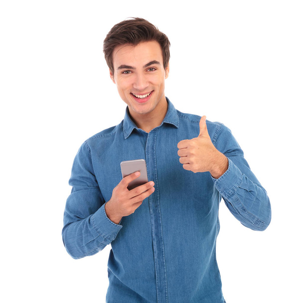man reading messages on phone and makes ok sign - Foto, Imagem