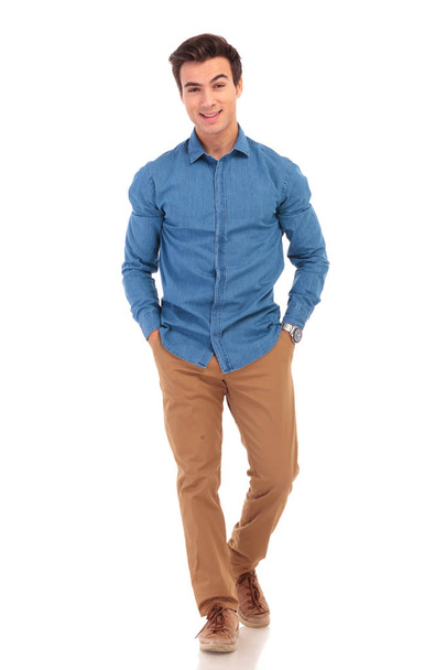 happy young casual man with hands in pockets smiling - 写真・画像