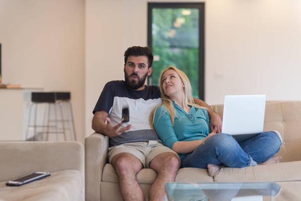 mladý šťastný pár uvolňuje v obývacím pokoji - Fotografie, Obrázek