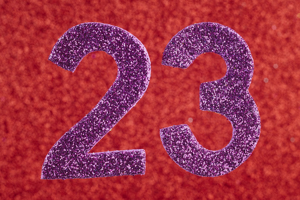 Nummer drieëntwintig paars op een rode achtergrond. Verjaardag.  - Foto, afbeelding