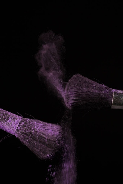 Μακιγιάζ βούρτσα με μωβ σκόνης σε μαύρο φόντο - Φωτογραφία, εικόνα