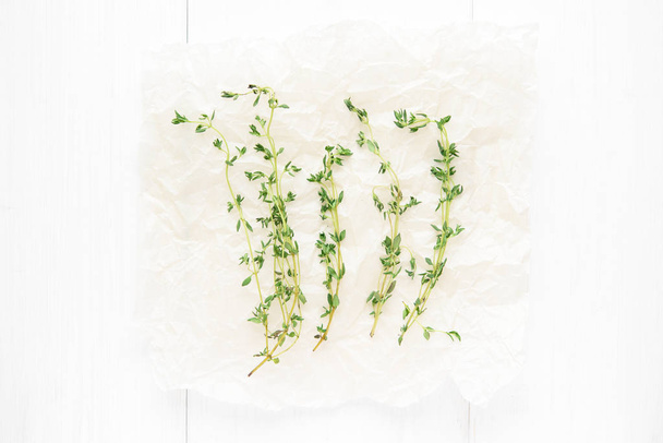 Dried thyme on baker paper on white background. Top view - Foto, afbeelding