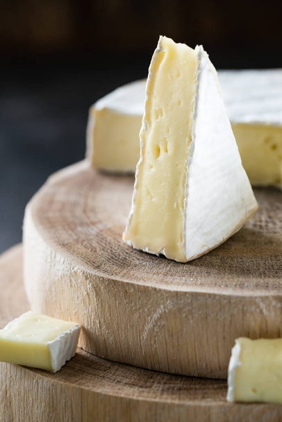 Pehmeä juusto brie viipaloitu puupaloja tumma maalaismainen tausta lähikuva
 - Valokuva, kuva