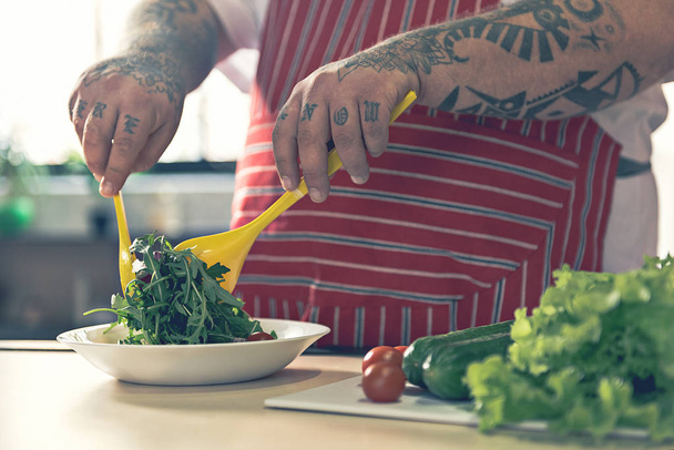 Kövér férfi főzés friss saláta - Fotó, kép