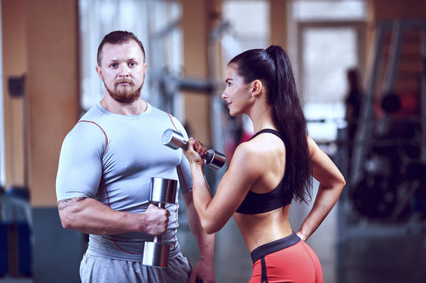 Couple doing workout on fitness machine at gym.  - Foto, Bild