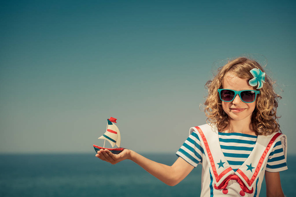 Παιδί με ιστιοπλοϊκό σκάφος στις καλοκαιρινές διακοπές - Φωτογραφία, εικόνα