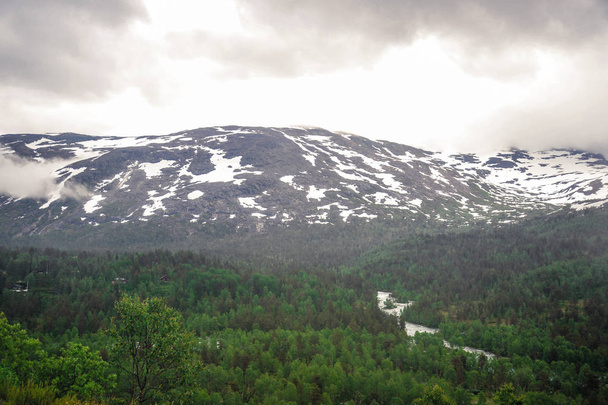 Όμορφη θέα τοπίο και τοπίο της Νορβηγίας, καταπράσινο τοπίο των λόφων και των βουνών μερικώς καλυμμένα με χιόνι - Φωτογραφία, εικόνα