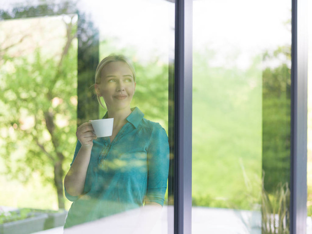 fiatal nő iszik kávé reggel, az ablak - Fotó, kép